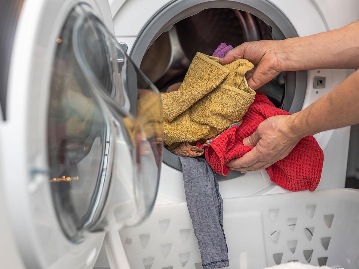 Person tager vasketøj ud af vaskemaskinen