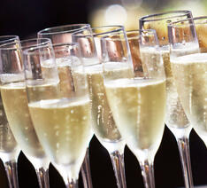 Champagne glas stillet op ved siden af hinanden med boblende champagne skænket op. 