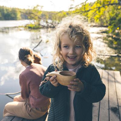 Barn ude for ved en sø med sin familie