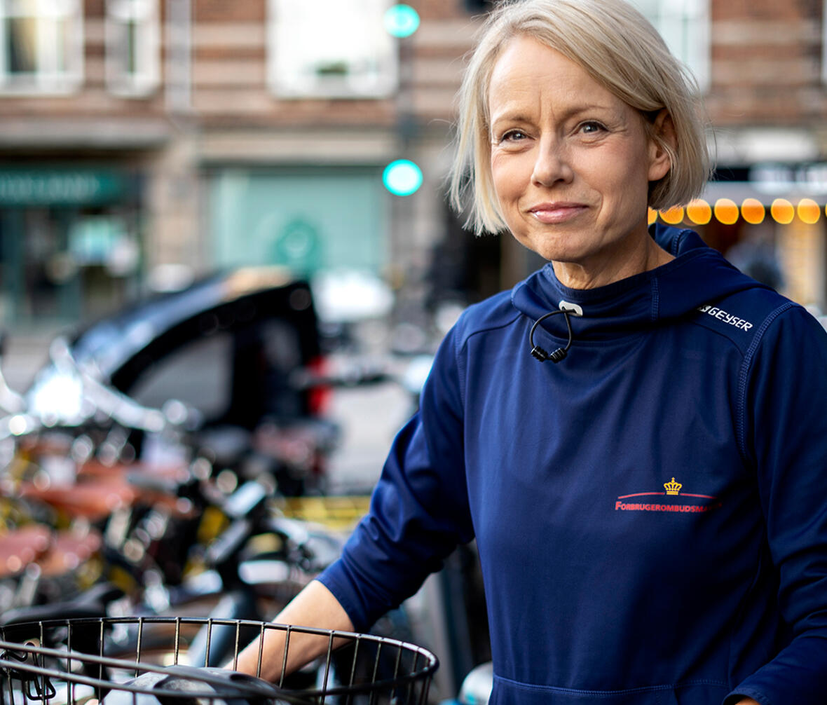 Halvtotal af Forbrugerombudsmand Christina Toftegaard der står med en cykel udenfor