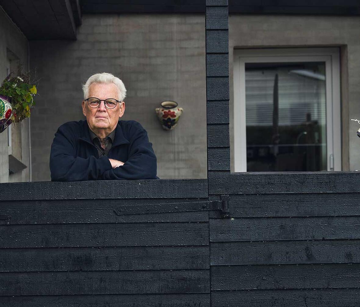 Halvnært foto af Bjarne Andersen, der står på sin terrasse