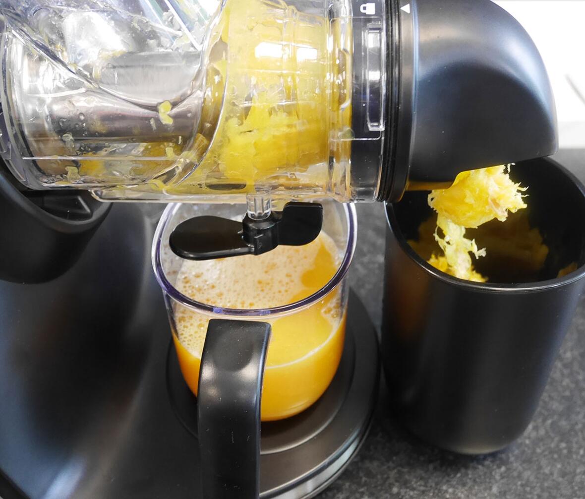 Juicemaskine i gang med at lave appelsinjuice i test af juicemaskiner.