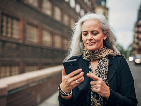 Kvinde kigger på sin telefon fordi hun har modtaget en svindelbesked