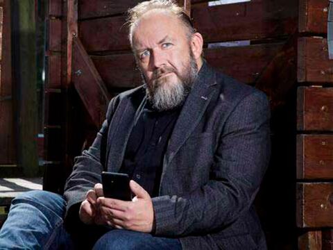 Adam Bindslev sidder med sin mobil
