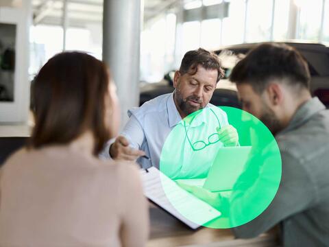 Mand og kvinde ved skrivebordet hos en biludlejer 