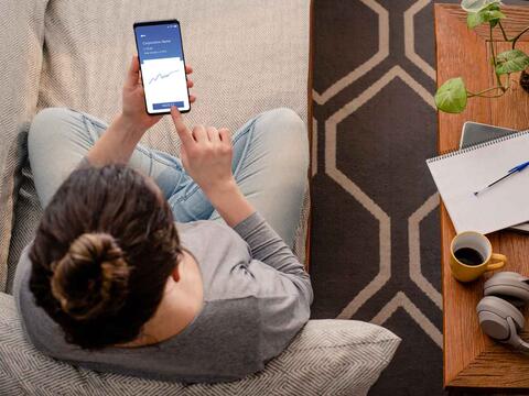 kvinde i sofa med telefon