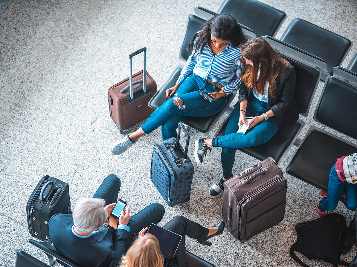 Personer der sidder i en lufthavn og venter