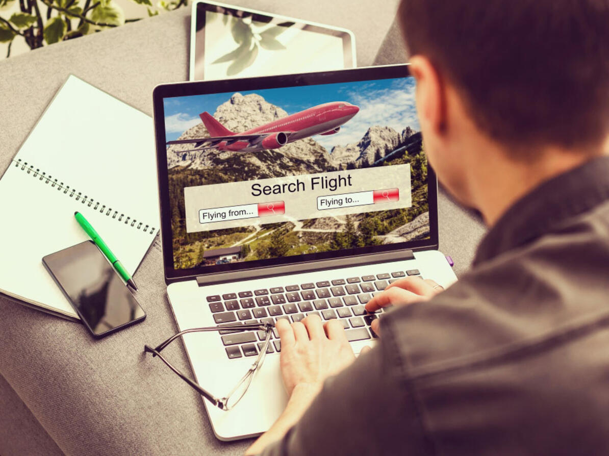 Mand leder efter flybillet på sin computer