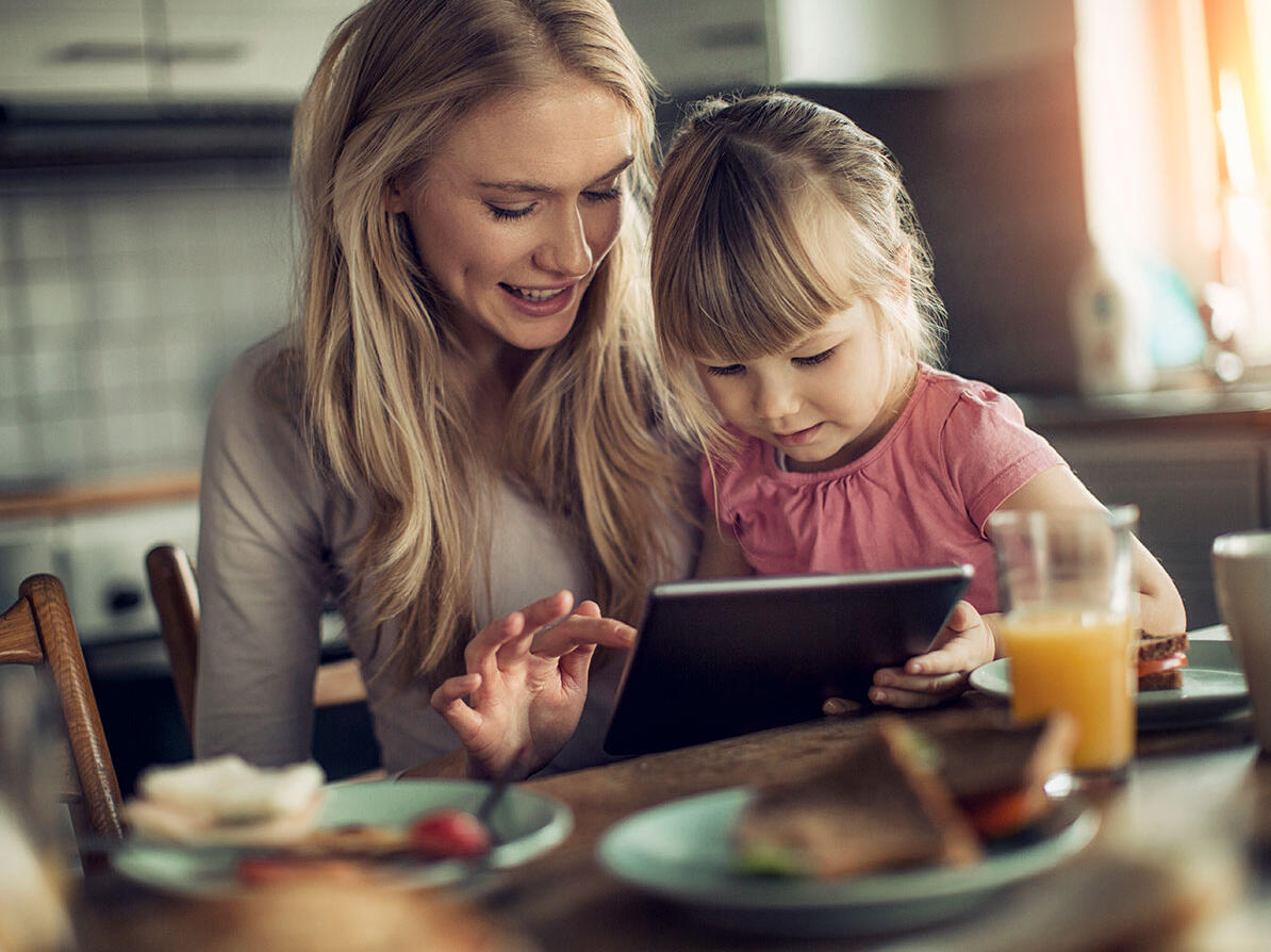 En mor og datter sidder og kigger på tablet og skal undgår greenwashing ved køb af produkter 