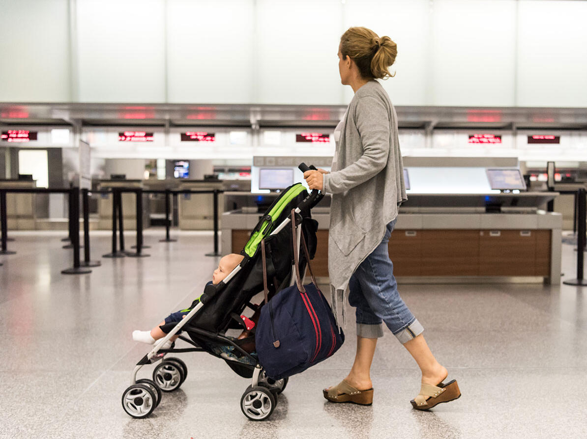 Kvinde med en klapvogn i en lufthavn