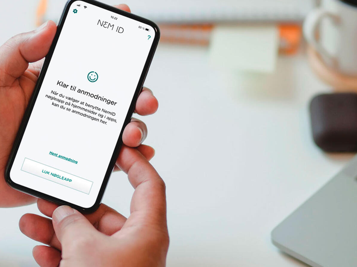 Person holder mobil med NemID-appen på.