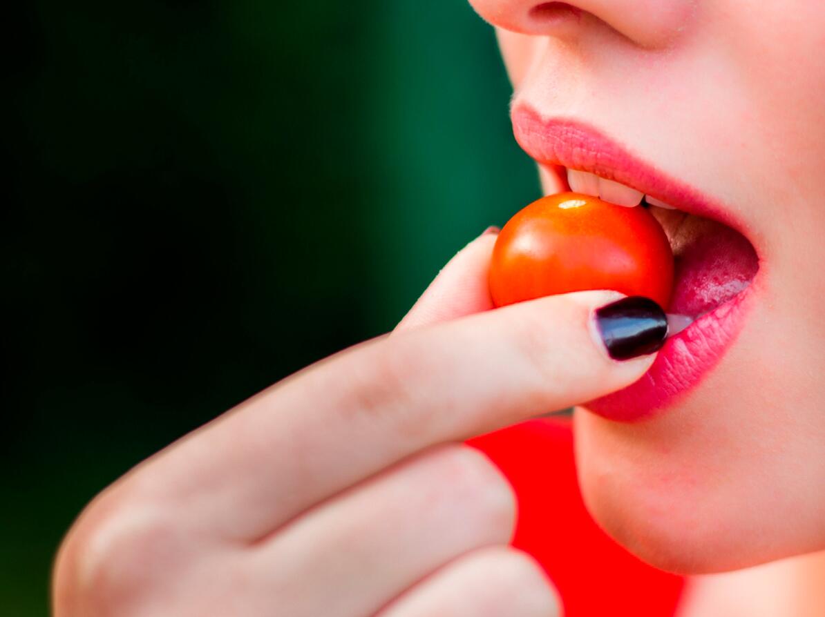 Person spiser en tomat
