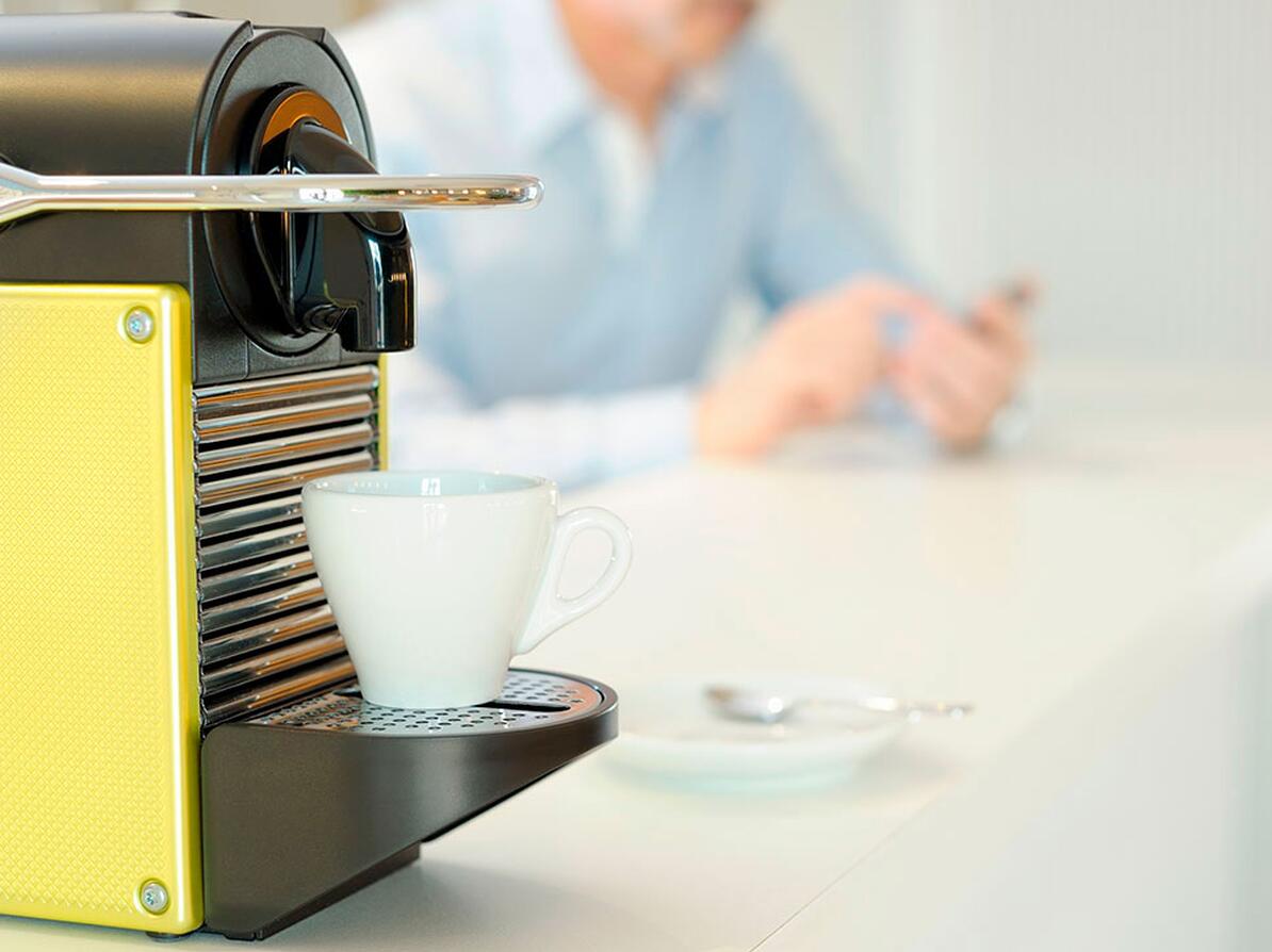 Espressomaskine med en kop på et bord 