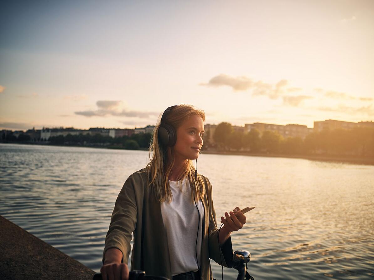 Kvinde går med sin cykel imens hun lytter til musik