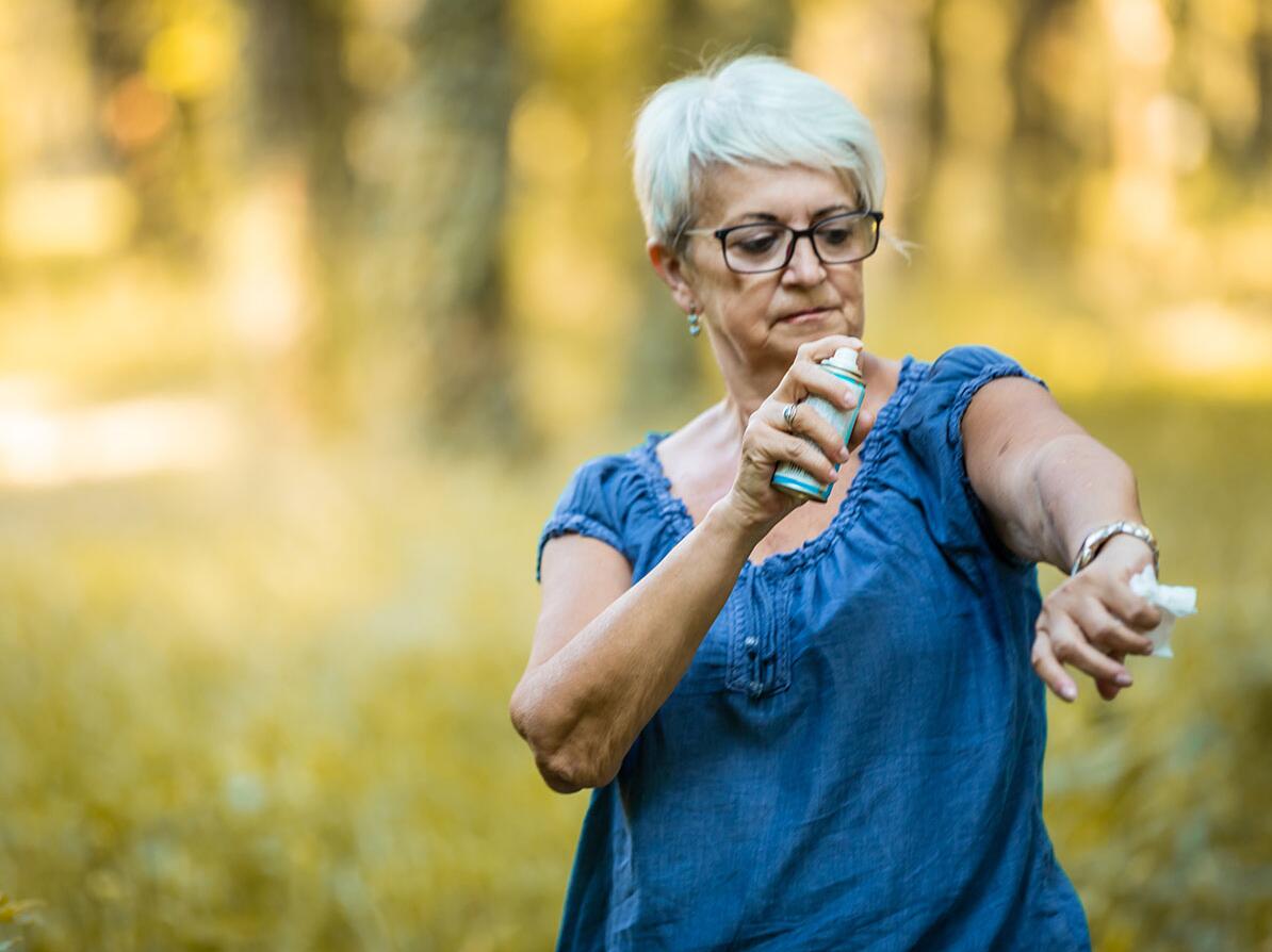 Kvinde benytter myggespray på sin arm