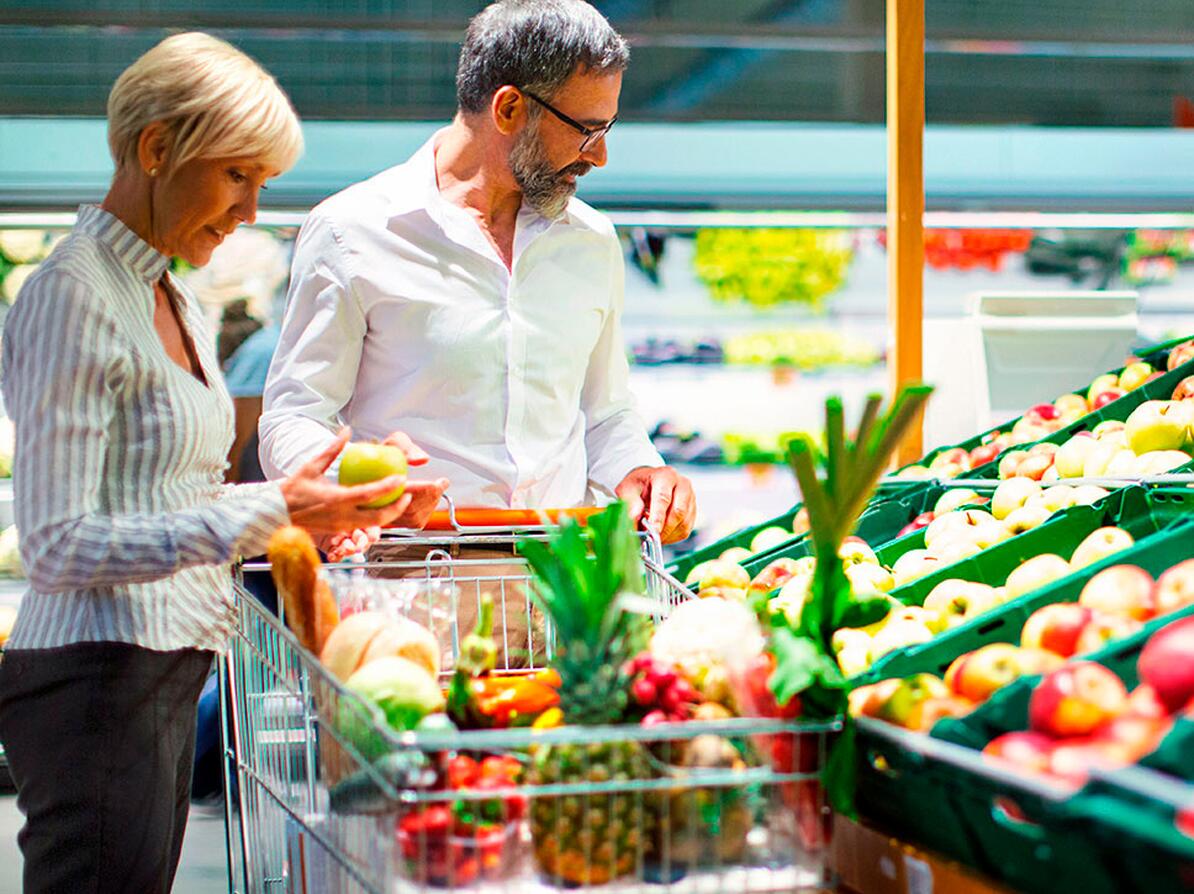 En mand og en kvinde køber grøntsager ind i et supermarked