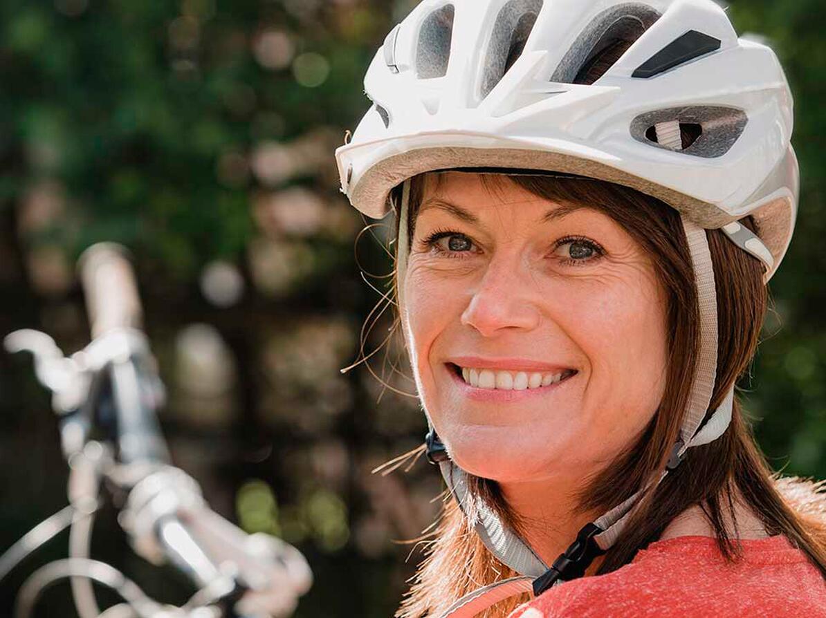 Kvinde bærer en cykelhjelm