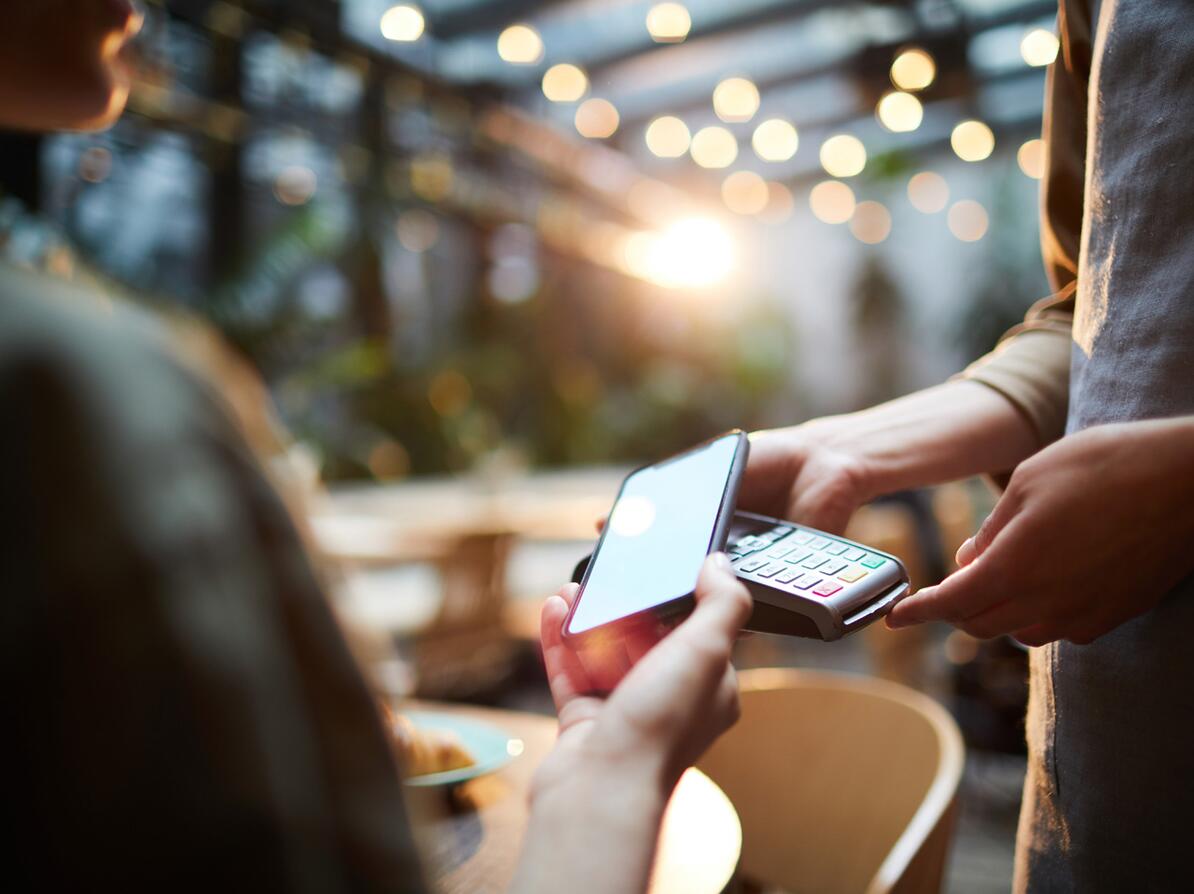 Kvinde betaler med mobilepay på cafe