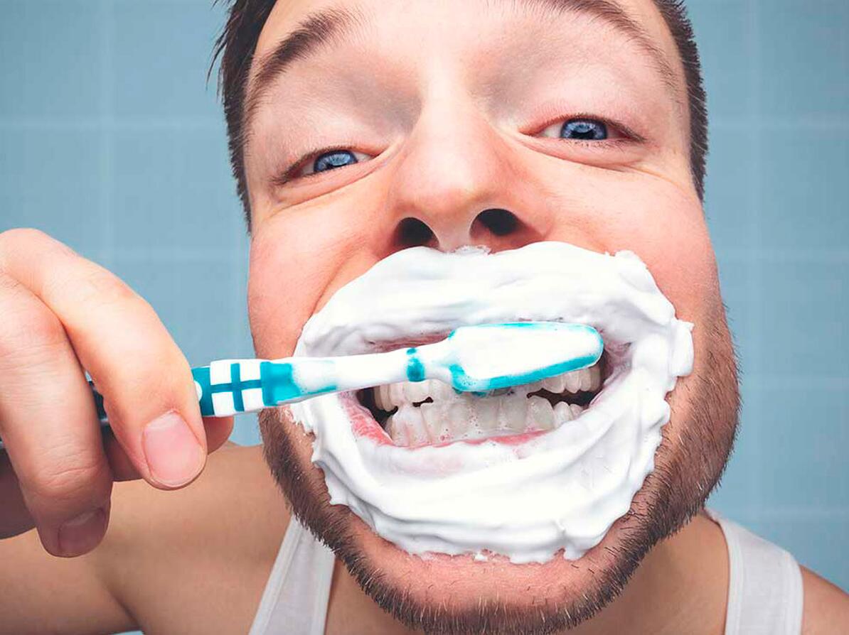 Person der børste tænder og tænker på fluor, slibeeffekt og SLS