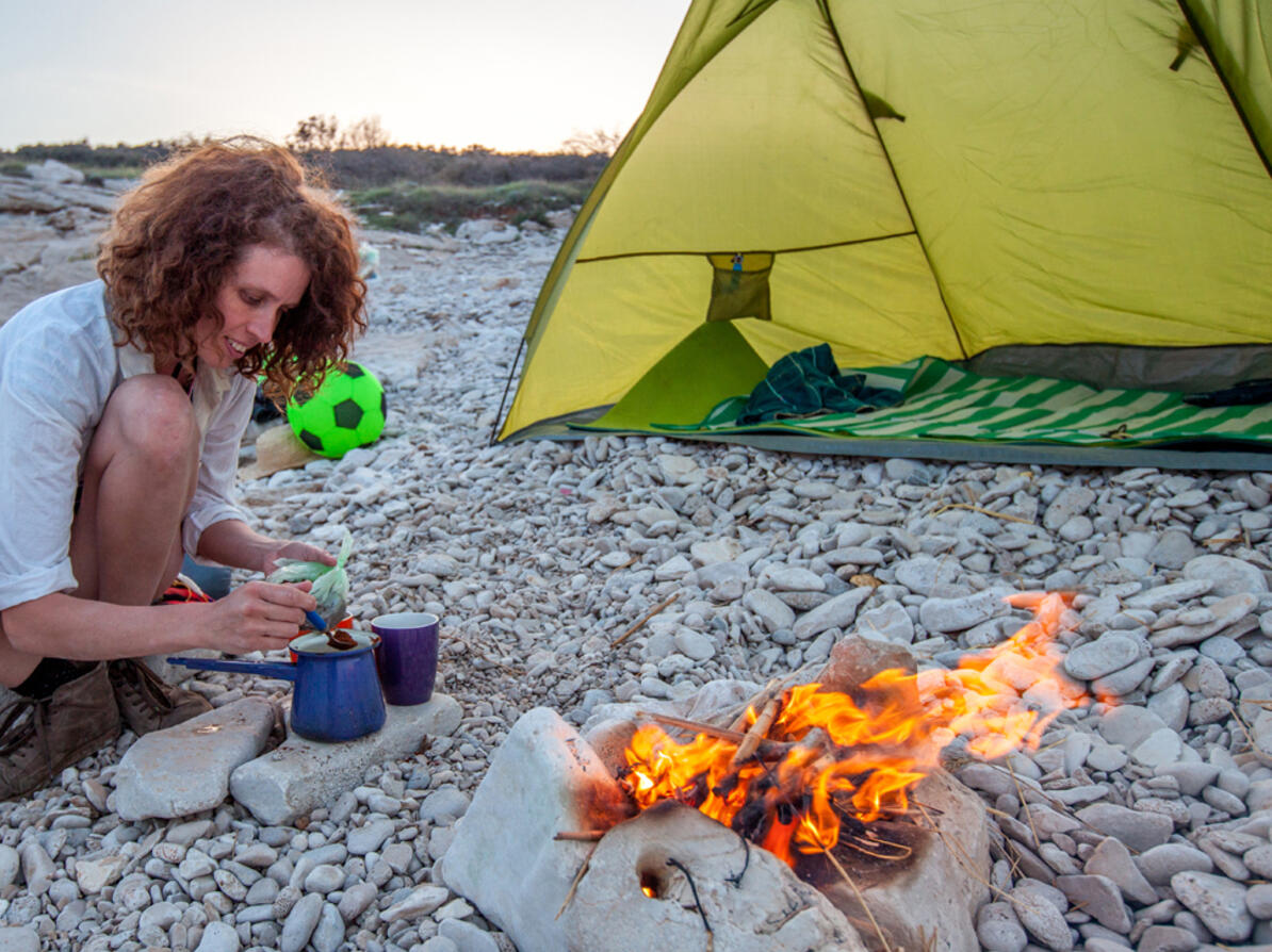 Person laver kaffe på campingtur med instant kaffe