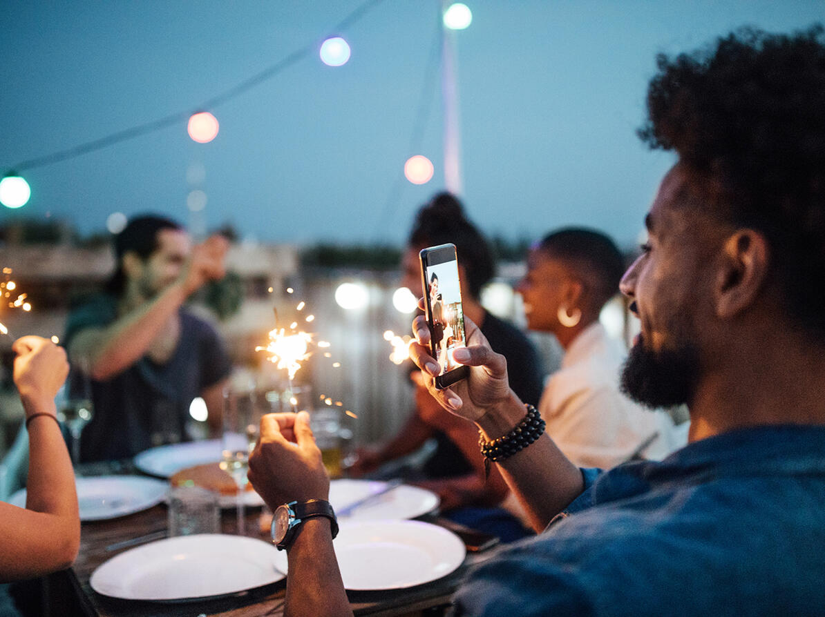 Mand tager foto med smartphone til en fest med venner