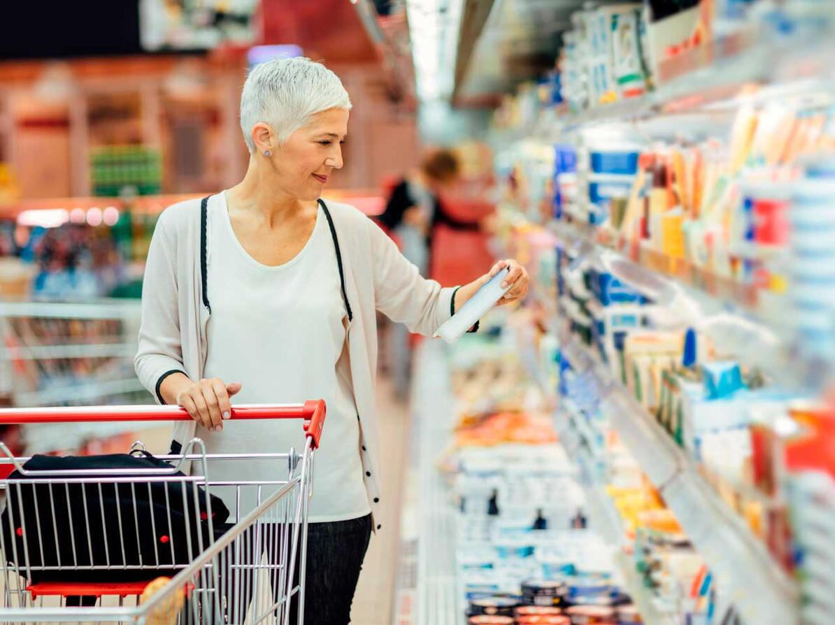 Kvinde kigger på dagligvarer i supermarked