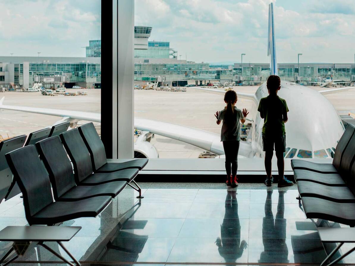 To børn venter på et forsinket eller aflyst fly i en lufthavn
