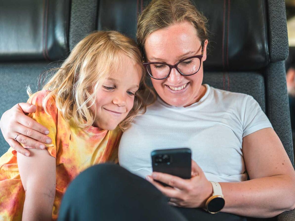 Mor og søn kigger på mobiltelefon
