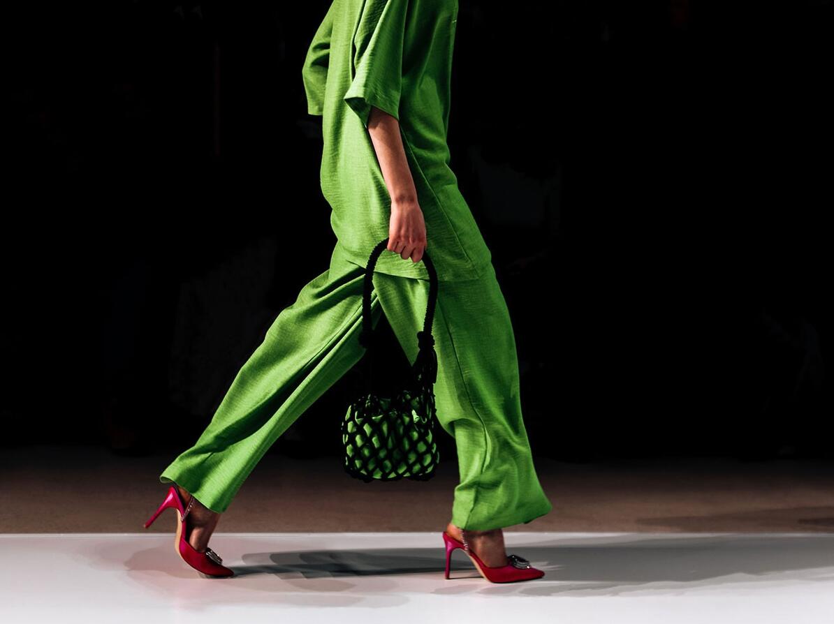 model på catwalk i grønt tøj går mod højre
