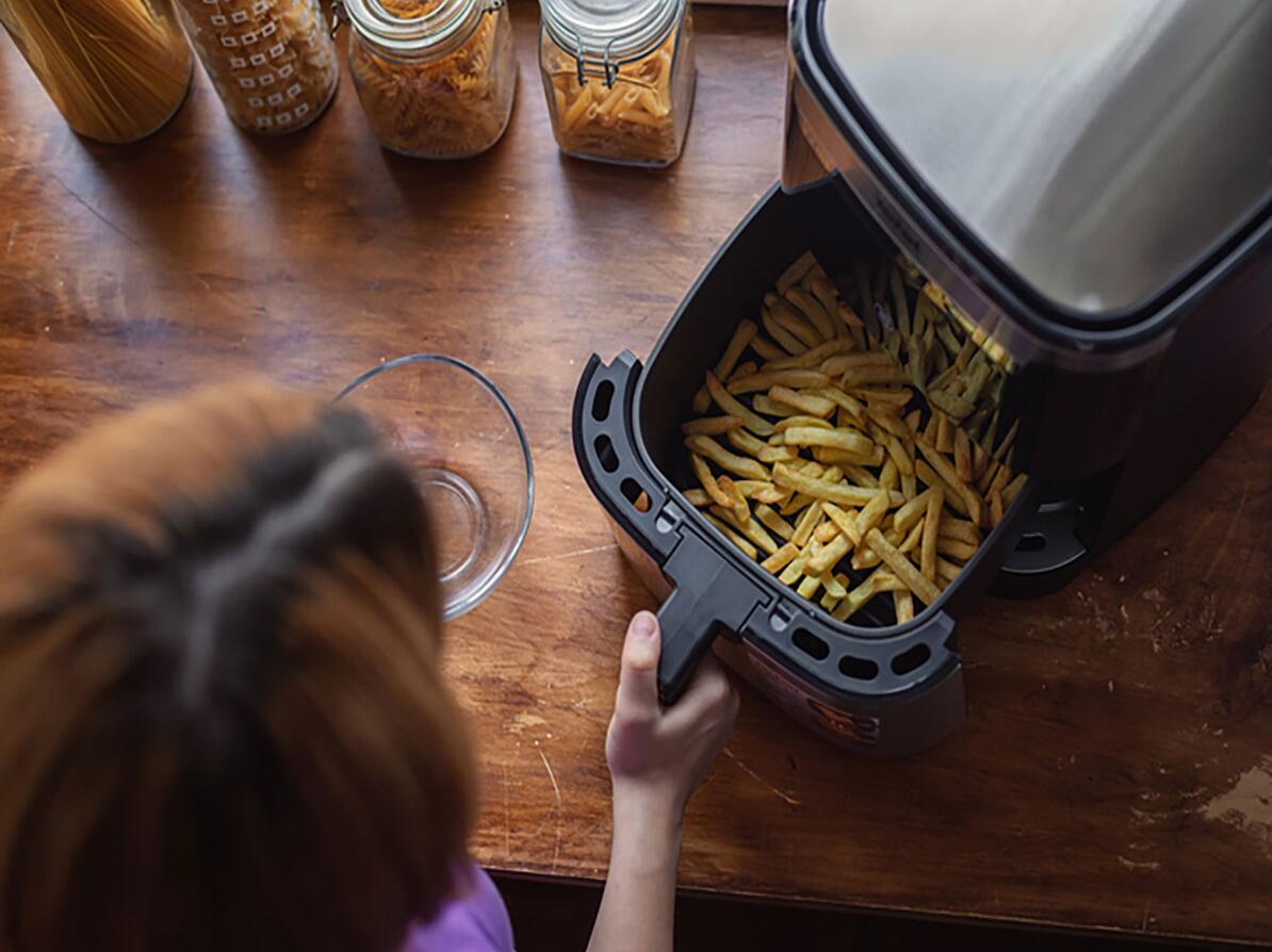 Person er i gang med at lave pomfritter i airfryer
