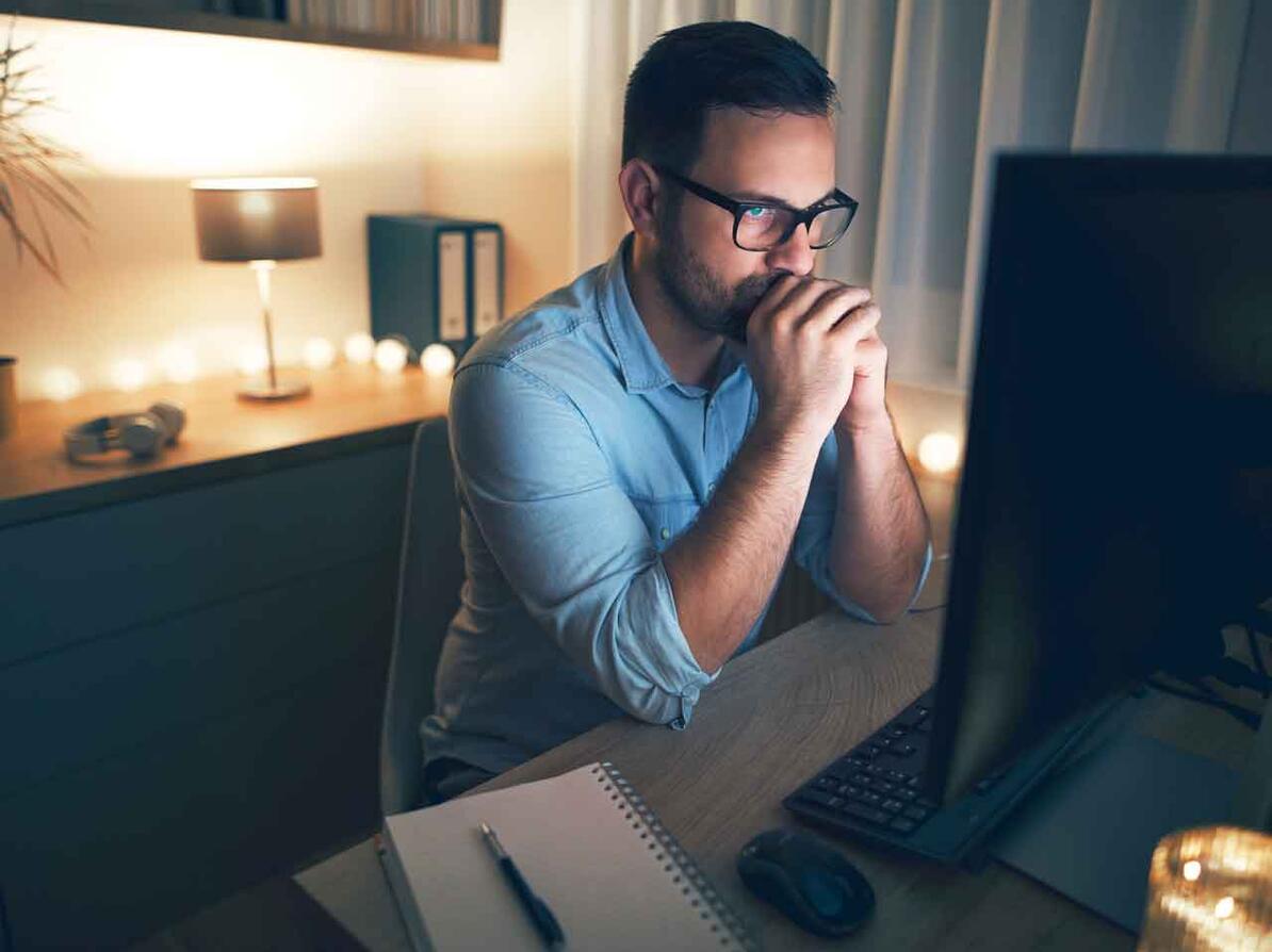 Mad sidder og kigger på computer og overvejer hvor han skal placere sin opspsaring