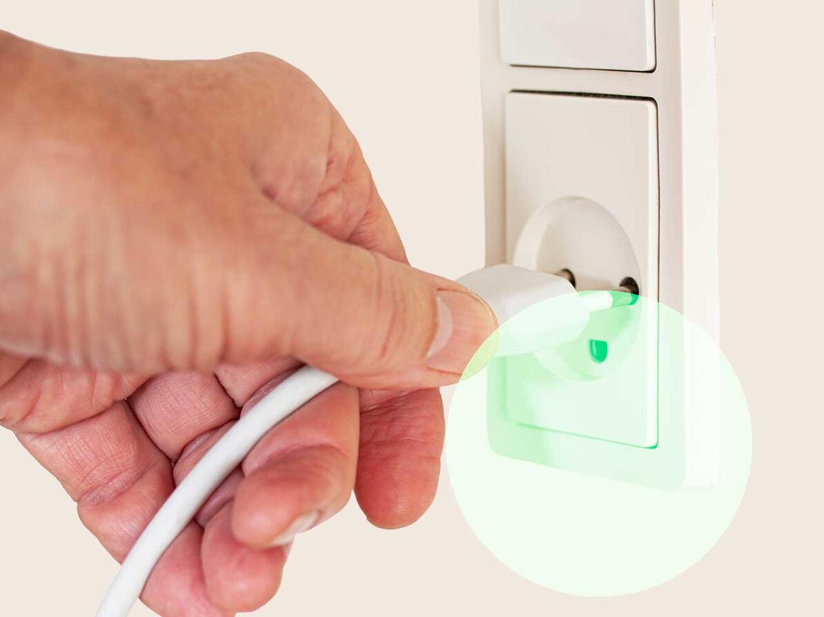 Hånd med ledning og stik og stikkontakt