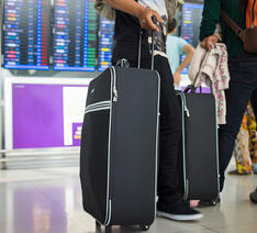 Personer med deres kufferter i lufthavnen 