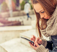 pige kigger på smartphone og skal undgå falske brugeranmeldelser
