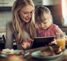 En mor og datter sidder og kigger på tablet og skal undgår greenwashing ved køb af produkter 