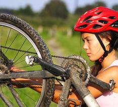 kvinde ser på sine gear på sin cykel