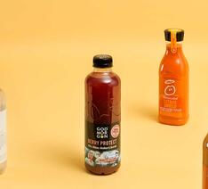juice, vitaminvand, smoothie står side om side på orange baggrund. 