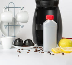 Espressomaskine, kapsler, citroner og kaffekopper 