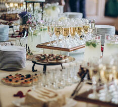 Opstillet catering buffet med pindemadder, champagne, kage og andre lækkerier 