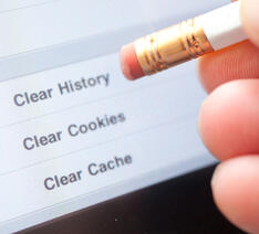 En person bruger sin blyant til at trykke på en skærm og slette sin cookie historie på nettet