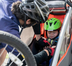 Barn sættes i anhænger til cykel