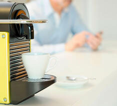 Espressomaskine med en kop på et bord 