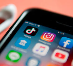 Smartphone med apps såsom Facebook, TikTok og Instagram