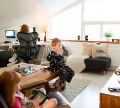 Børn der ser tv, og en person der sidder ved en computer
