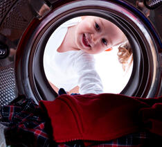 Barn der kigger ind i vaskemaskine hvidevarer