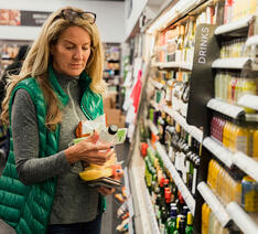 Kvinde kigger på en vare i supermarkedet