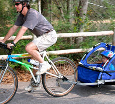 En person cykler med en cykelanhænger bagpå