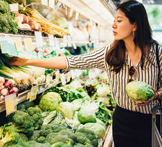 kvinde kigger på grøntsager i supermarkedet.