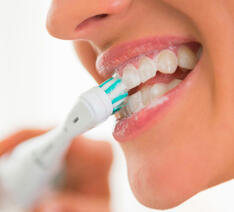Person der børster tænder med tandpasta med whitening