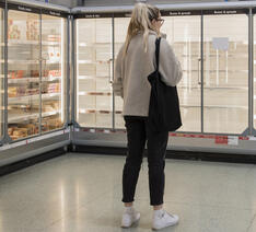 Kvinde i supermarked med tomme hylder